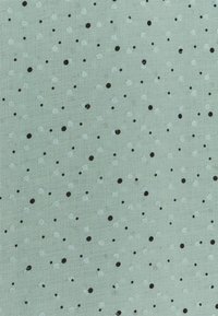 Tessuto verde chiaro con una superficie texture, caratterizzato da un motivo di punti neri e bianchi di diverse dimensioni distribuiti uniformemente su tutto il materiale.