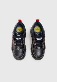 Sneaker in pelle nera con linguette rosse sul tallone, chiusura con lacci e dettagli argentati. Presenta un interno imbottito e un logo rotondo sulla linguetta.