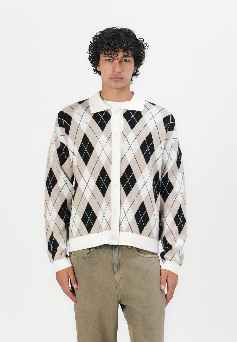 Cardigan featuring a cream collar, button front, and an argyle pattern in beige, black, and white. Soft knit fabric with ribbed cuffs.