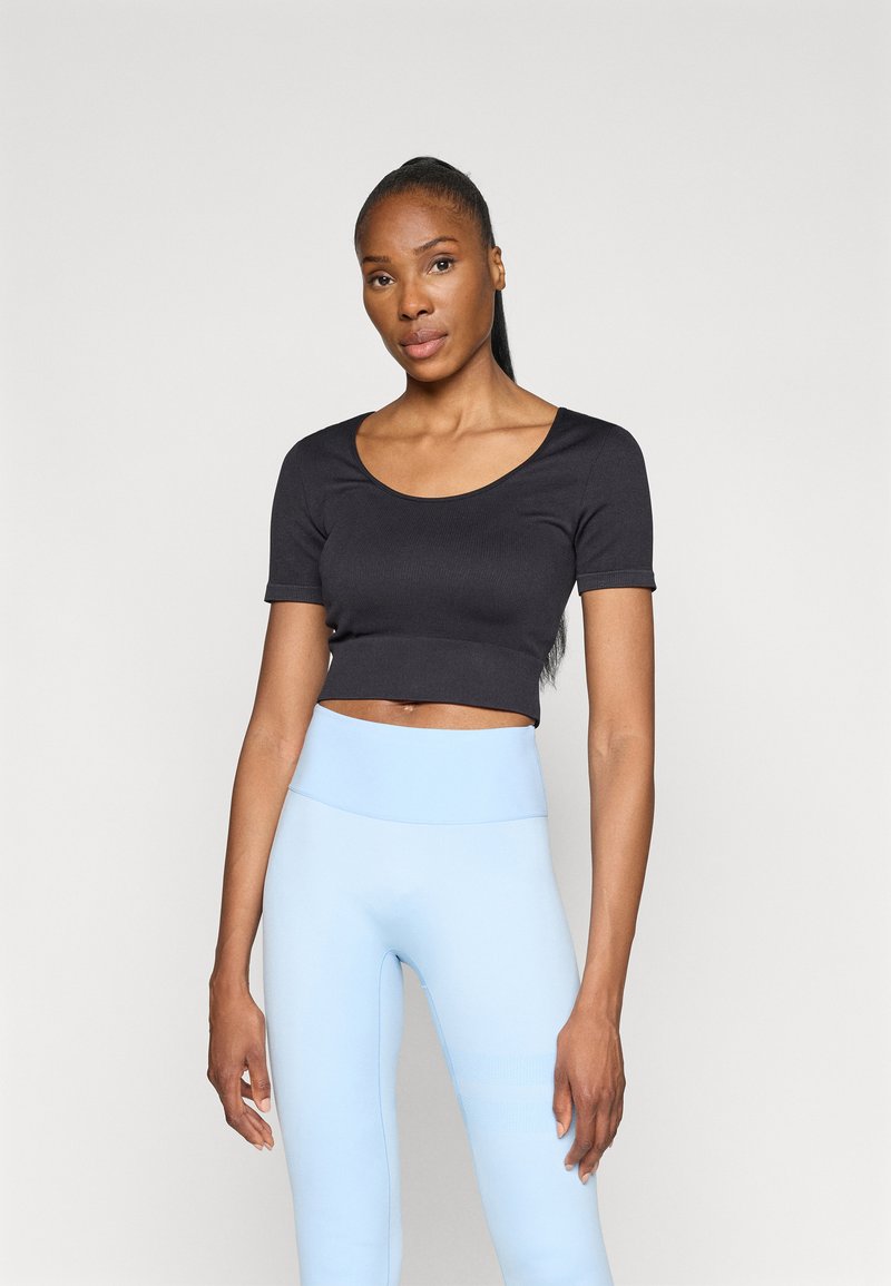 Black ribbed cropped top with short sleeves paired with light blue high-waisted leggings, smooth texture, simple design, minimal accents.