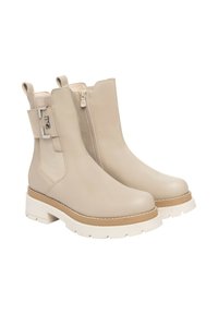 Stivali alla caviglia beige con esterno in pelle liscia, cerniera laterale, suola bianca spessa e una fascia decorativa con un accento argentato.