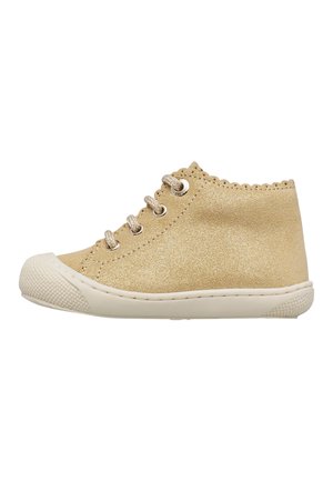 Sneaker beige glitterata alta per bambini con suola e punta in gomma bianca, allacciatura frontale e bordo smerlato intorno alla caviglia.