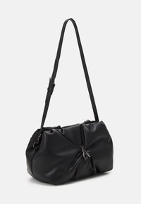 Borsa in pelle sintetica nera con un design annodato, texture lucida, tracolla regolabile e accento centrale in metallo argentato.