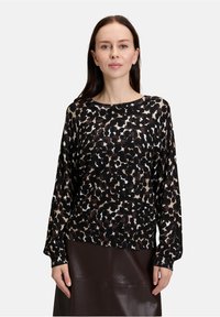 Długi rękaw z topem w czarno-brązowy wzór lamparta z białymi akcentami, wykonany z lekkiego, teksturowanego materiału.