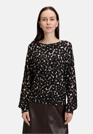 Maglia a maniche lunghe con stampa leopardata nera e marrone, impreziosita da dettagli bianchi, realizzata in un tessuto leggero e texture morbida.