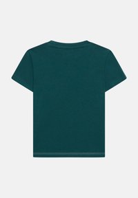 T-shirt med korte ærmer i mørk teal bomuld. Har rund halsudskæring og standard pasform med dobbeltstikninger ved kanten for holdbarhed.