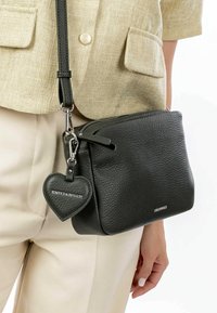 Borsa a tracolla nera in pelle con finitura texture, chiusura con zip, tracolla regolabile e un'etichetta a forma di cuore con logo.