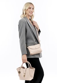 Borsa a tracolla in pelle beige con texture, dotata di doppio manico e metalleria color oro, abbinata a una borsa crossbody più piccola dello stesso tono.