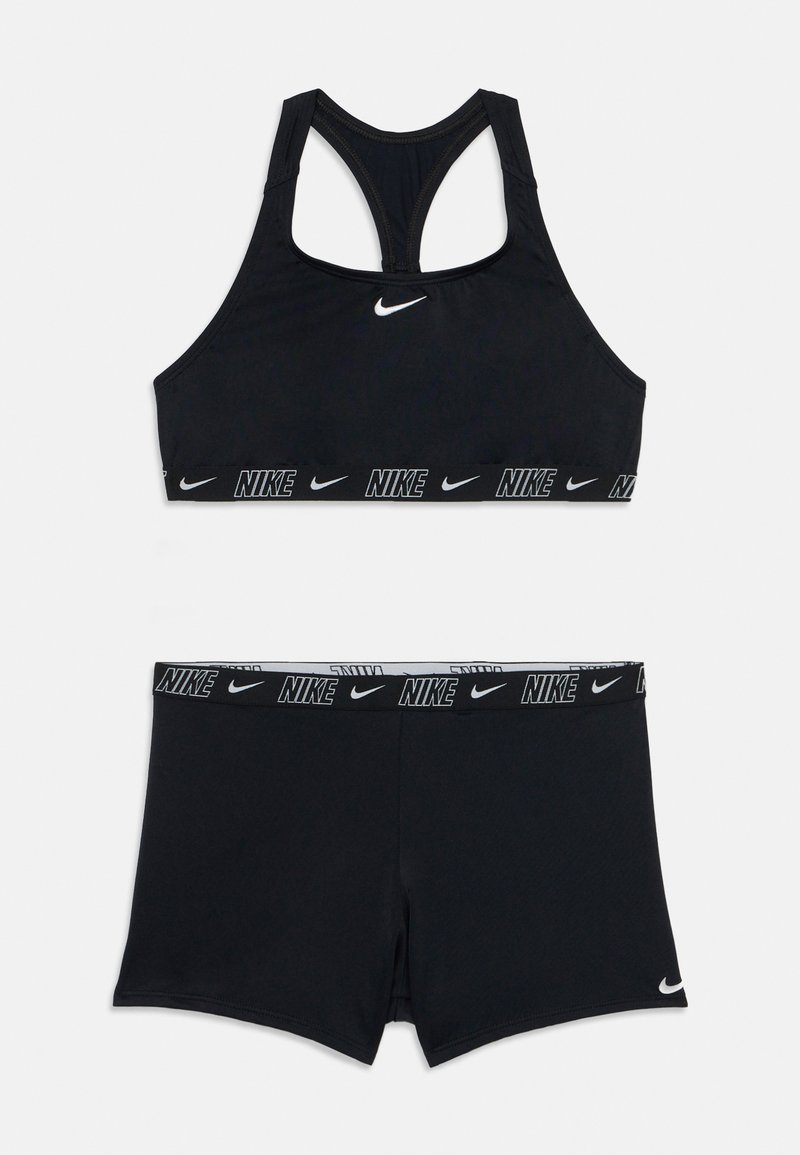 Melnas sporta krūšturis un šorti, kas izgatavoti no stiept auduma, ar racerback dizainu, Nike logotipu un zīmola elastīgām joslām jostasvietā.