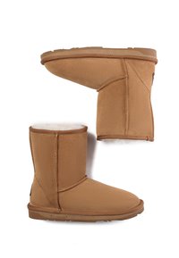 Beige Stiefeletten aus weichem Wildleder mit einem Futter aus Schafswolle, flacher Gummisohle und Seitennähten.