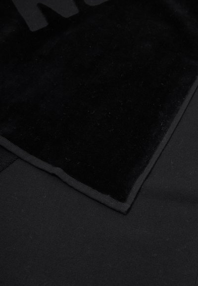 Juodas audinys su minkštu, veliūro paviršiumi ir lygiu kraštu. Medžiaga yra lengva ir turi matinį apdailą.