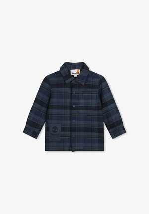 Camicia flanella a quadri in navy e nero, con chiusura a bottoni frontale, colletto e patch logo sul lato sinistro del petto. Maniche lunghe e vestibilità standard.