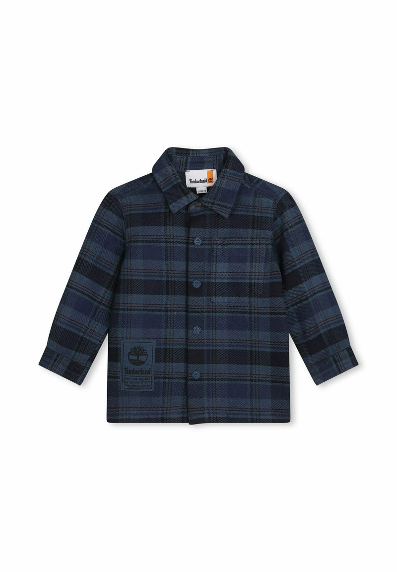 Camicia flanella a quadri in navy e nero, con chiusura a bottoni frontale, colletto e patch logo sul lato sinistro del petto. Maniche lunghe e vestibilità standard.