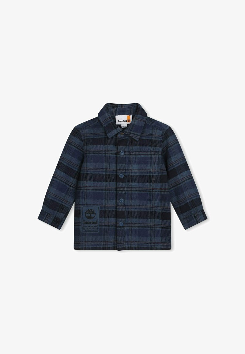 Camicia flanella a quadri in navy e nero, con chiusura a bottoni frontale, colletto e patch logo sul lato sinistro del petto. Maniche lunghe e vestibilità standard.