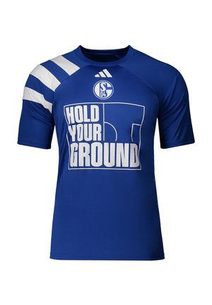 Modré sportovní tričko s bílými diagonálními pruhy na jednom rukávu, logem Adidas, znakem Schalke 04 a textem "HOLD YOUR GROUND" s grafikou hřiště.