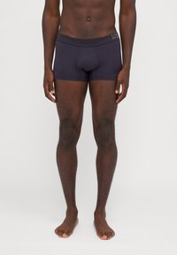 Dunkelmarineblaue Boxershorts aus glattem Stoff, mit enganpassendem Schnitt und einem weichen Bund mit dezentem Branding.