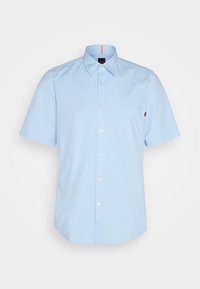 Camisa de boton corto de manga corta en azul claro, con cuello, un bolsillo en el pecho y botones blancos. Hecha de una tela suave con una textura sutil.