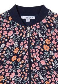 Giacca bomber floreale con sfondo navy e piccoli fiori rosa, arancioni e verdi, chiusura con zip e colletto a costine.
