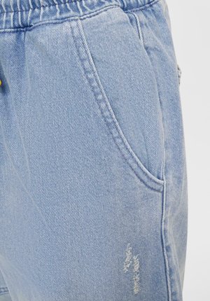 Light blue denim pants with an elastic waistband, side pockets, and distressed detailing on the fabric for a casual look.