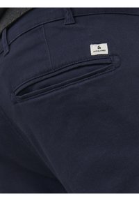 Tmavě modré kalhoty s hladkou texturou, opatřené zadní kapsou a malou bílou štítkem s logem "JACK & JONES".