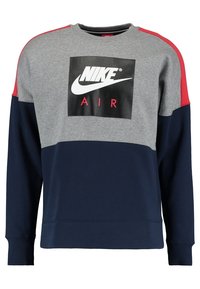 Grå och marinblå sweatshirt med röda detaljer, med en svart Nike Air-logotyp på framsidan. Långa ärmar och en bekväm passform.