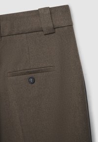 Braune, strukturierte Hosen mit flachem Frontdesign, seitlichen Taschen und einer einzigen Gesäßtasche mit schwarzem Knopfverschluss.