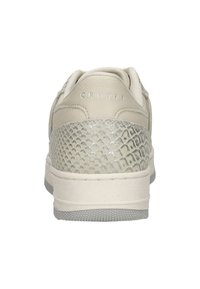 Beige sneaker met een gestructureerde zilveren slangenhuidprint op de hiel, met glad leer en tonale stiksels. Witte zool met een subtiel gripdesign.