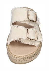 White canvas sandals with frayed straps, featuring two gold buckles and a jute-wrapped sole. Flat footbed with a soft, light-colored texture.