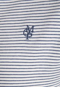 Materiał bawełniany w paski w kolorze białym i granatowym, z haftowanym logo w kolorze granatowym. Paski są cienkie i równomiernie rozmieszczone.