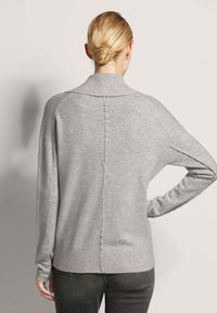 Grijze, gebreide trui met een hoge kraag, oversized pasvorm en geribbelde zoom. Voorzien van een middennaad en een ontwerp met verlaagde schouders.