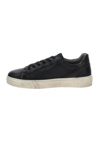 Zwarte lage leren sneaker met zwarte veters en een dikke witte rubberen zool, zijaanzicht op een witte achtergrond.