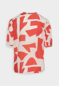 Rød og hvid mønstret bluse med en løs pasform, korte puffede ærmer og abstrakte geometriske former på stoffet.