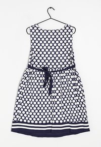 Vestido navy con lunares blancos, diseño sin mangas, cintura ceñida con cinturón de lazo y dobladillo a rayas.