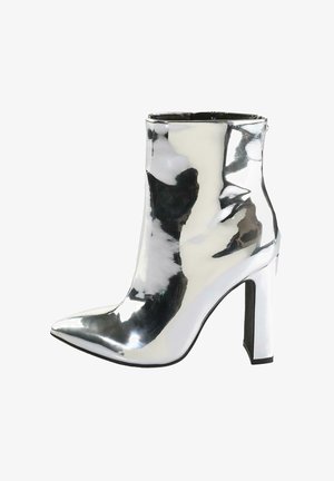 Srebrne lakierowane botki za kostkę z ostrym noskiem, grubym, wysokim obcasem i zamkiem błyskawicznym z boku, o gładkiej, błyszczącej teksturze.