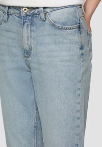 Jasnoniebieskie dżinsy mają prostą nogawkę, pięć kieszeni, zapięcie na górny guzik oraz subtelne wyblaknięcia dla uzyskania tekstury.