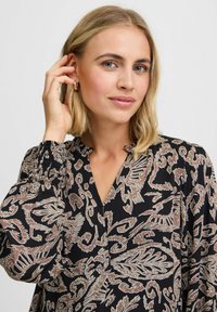 Bluză neagră cu un imprimeu floral paisley în bej, având un decolteu în V și mâneci bufante pliate pentru un plus de textură.
