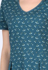 Türkises Baumwollkleid mit kurzen Ärmeln, V-Ausschnitt und ganzflächigem Kirschmuster in Hellblau und Gelb. Verfügt über eine geraffte Taille und Falten.