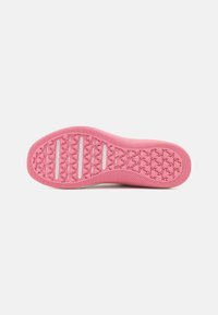 Suela de un zapato en un vibrante color rosa con un patrón texturizado, que presenta ranuras horizontales y un diseño de agarre en forma de diamante para tracción.