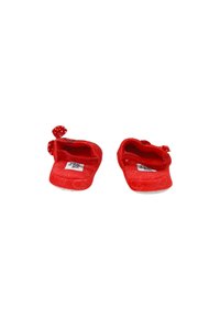 Pantofole di stoffa rossa con una consistenza morbida, caratterizzate da dettagli a pois e un design aperto sul retro. La suola è piatta con un minimo di battistrada.