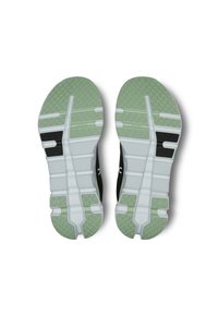 Czarne buty sportowe z zieloną i białą podeszwą. Podeszwa ma teksturowany wzór gripu oraz strukturalne linie dla elastyczności.