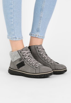 Graue Lederstiefeletten mit einem grauen Stoffkragen, runden Schnürsenkeln und einer strukturierten Gummisohle, die mit einem schwarzen Stoffakzent ausgestattet sind.