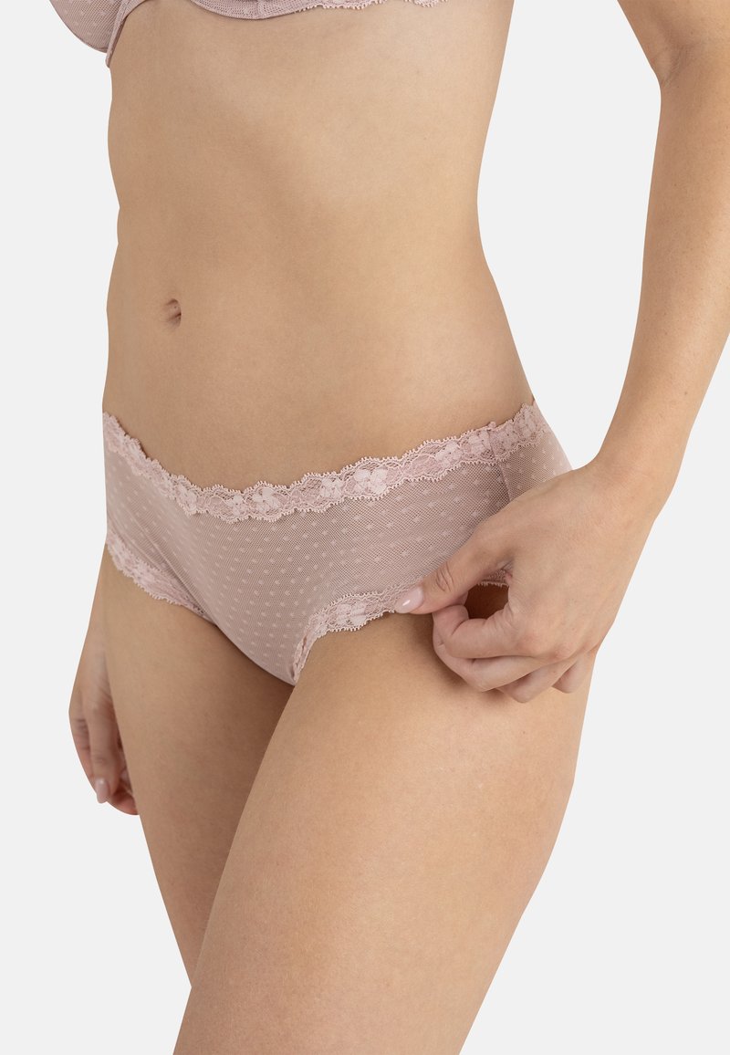 Culotte rose transparente à motif à pois, bordure en dentelle à la taille et texture lisse. Coupe ajustée et taille moyenne.