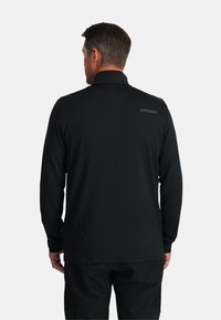Zwarte pullover met lange mouwen en een hoge kraag. Gemaakt van lichte stof, met een subtiel logo op de bovenrug. Gladde textuur.