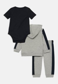 Grå hettegenser og joggebukse sett med marineblå striper, kombinert med en svart kortermet body. Myk stoff, uformell design.