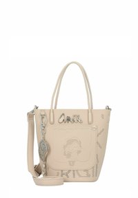 Beige Handtasche aus Kunstleder mit perforiertem Design, silbernem Zubehör, kurzen Griffen, abnehmbarem Schultergurt und dekorativem Schlüsselanhänger.