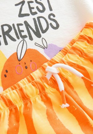 Baumwoll-T-Shirt mit dem Aufdruck "ZEST FRIENDS" und grafischen Elementen in Orange, kombiniert mit elastischen Shorts in Orange und Gelb mit Streifen und einer weißen Kordel.