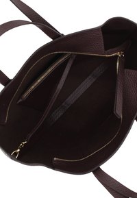 Dunkelbraunes Lederhandtascheninnere mit zwei goldenen Reißverschlüssen, einem zentralen Trennfach und zwei nach außen verlaufenden Griffen.