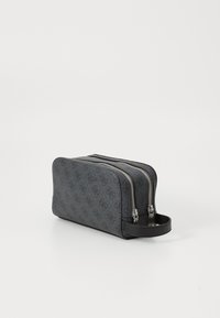 Schwarz bedruckte Kosmetiktasche mit Doppelreißverschlussfächern, rechteckiger Form, strukturiertem Material und seitlichem Griff.