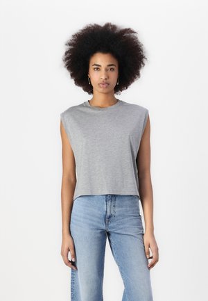 Grey cropped sleeveless t-shirt in lightweight fabric. Features a round neck and a relaxed fit. Paired with high-waisted light blue jeans.