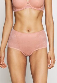 Biancheria intima rosa chiaro con un motivo in pizzo floreale, design a vita alta, texture morbida e bordi lisci. Costruzione semplice e senza cuciture.